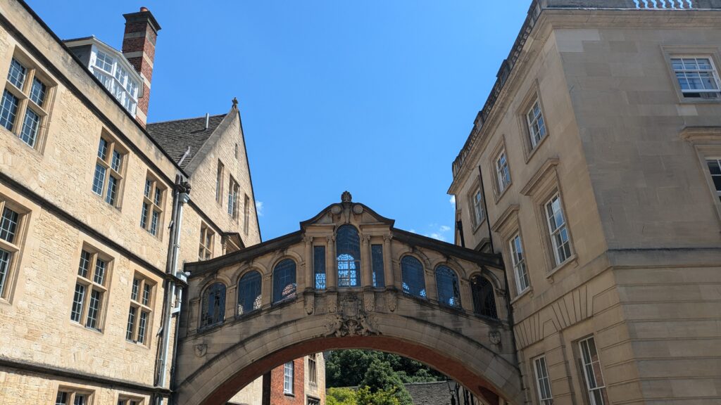Hertford College's bridge over New College Lane. Historic bridge in light brown stone joining two buildings.